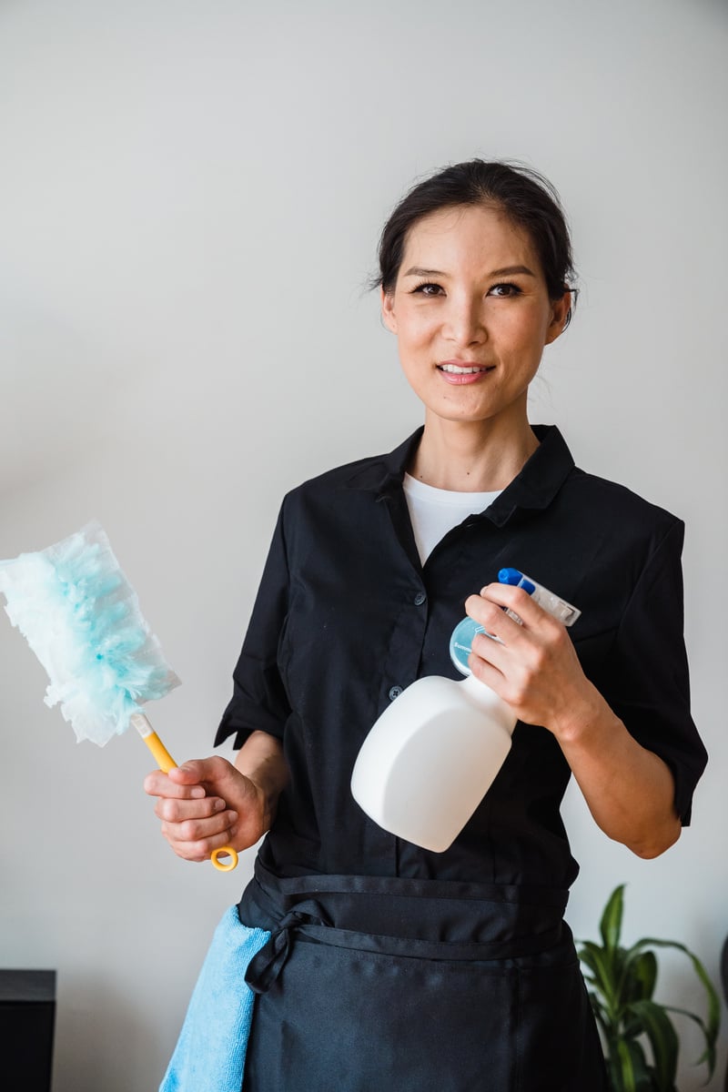 Woman in Black Shirt Holding White and Blue Sprayer Bottle